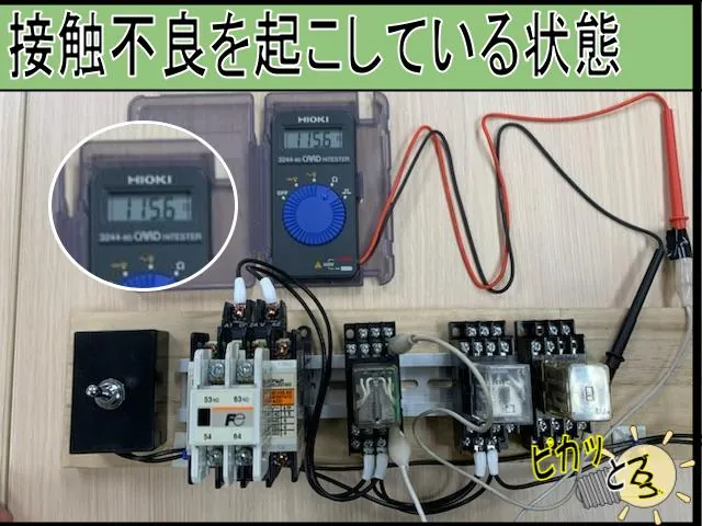 古いリレーの接点をテスターで抵抗測定している状態